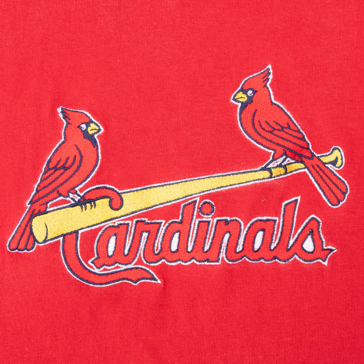 Close-up of St. Louis Cardinals birds-on-bat chest logo on red fabric
