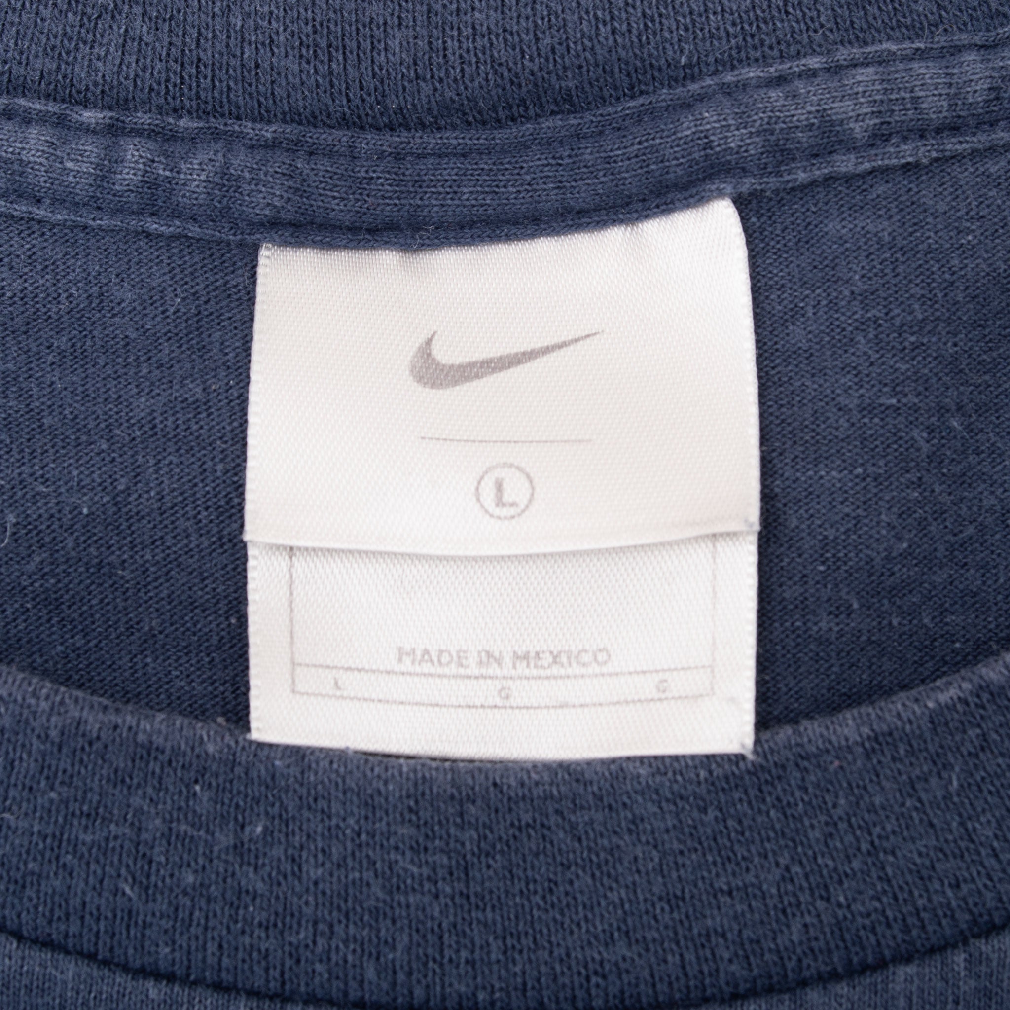 Close-up of Nike neck tag marked size large inside blue T-shirt