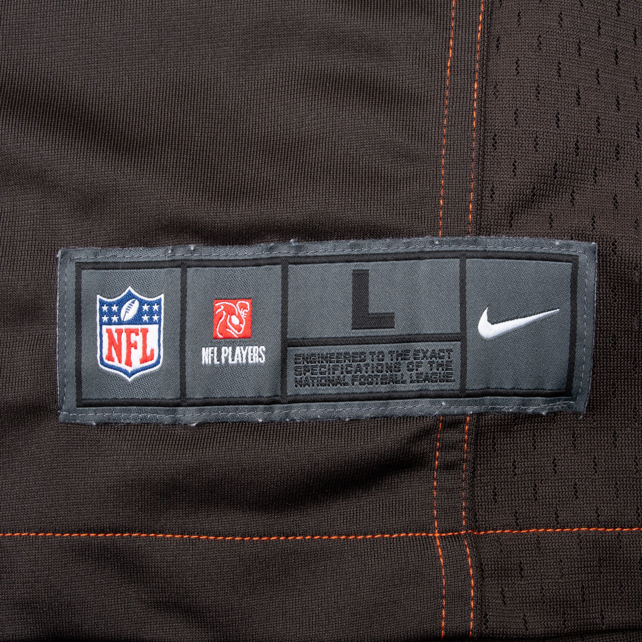 Nike NFL size large hem label beside orange stitching and mesh panel