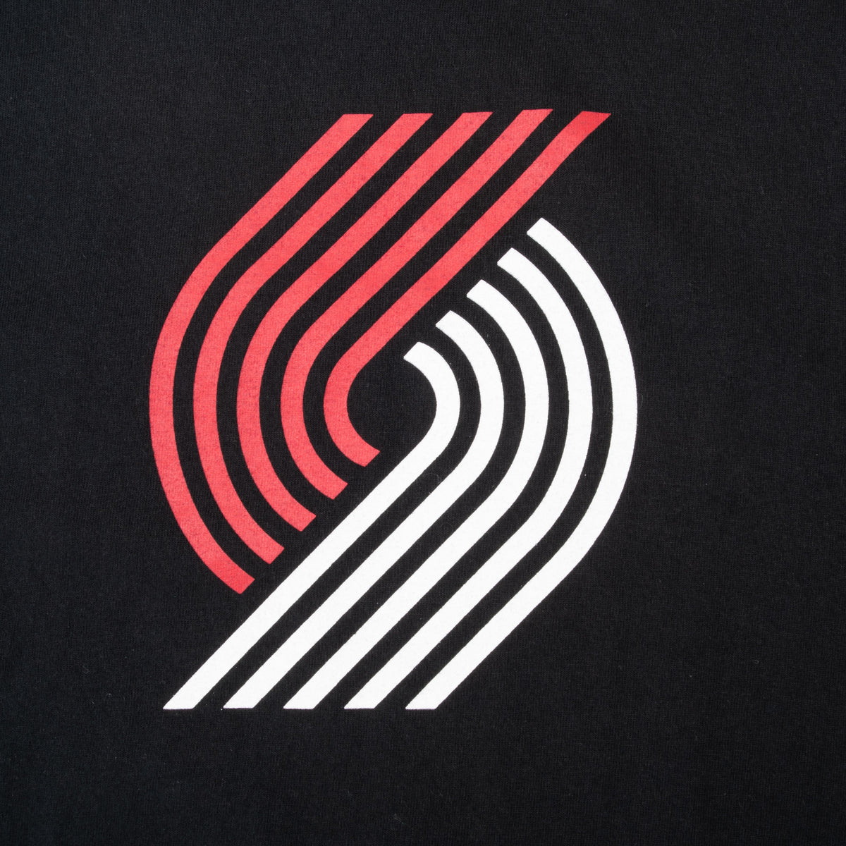 Close-up of red and white Portland Trail Blazers logo printed on black fabric