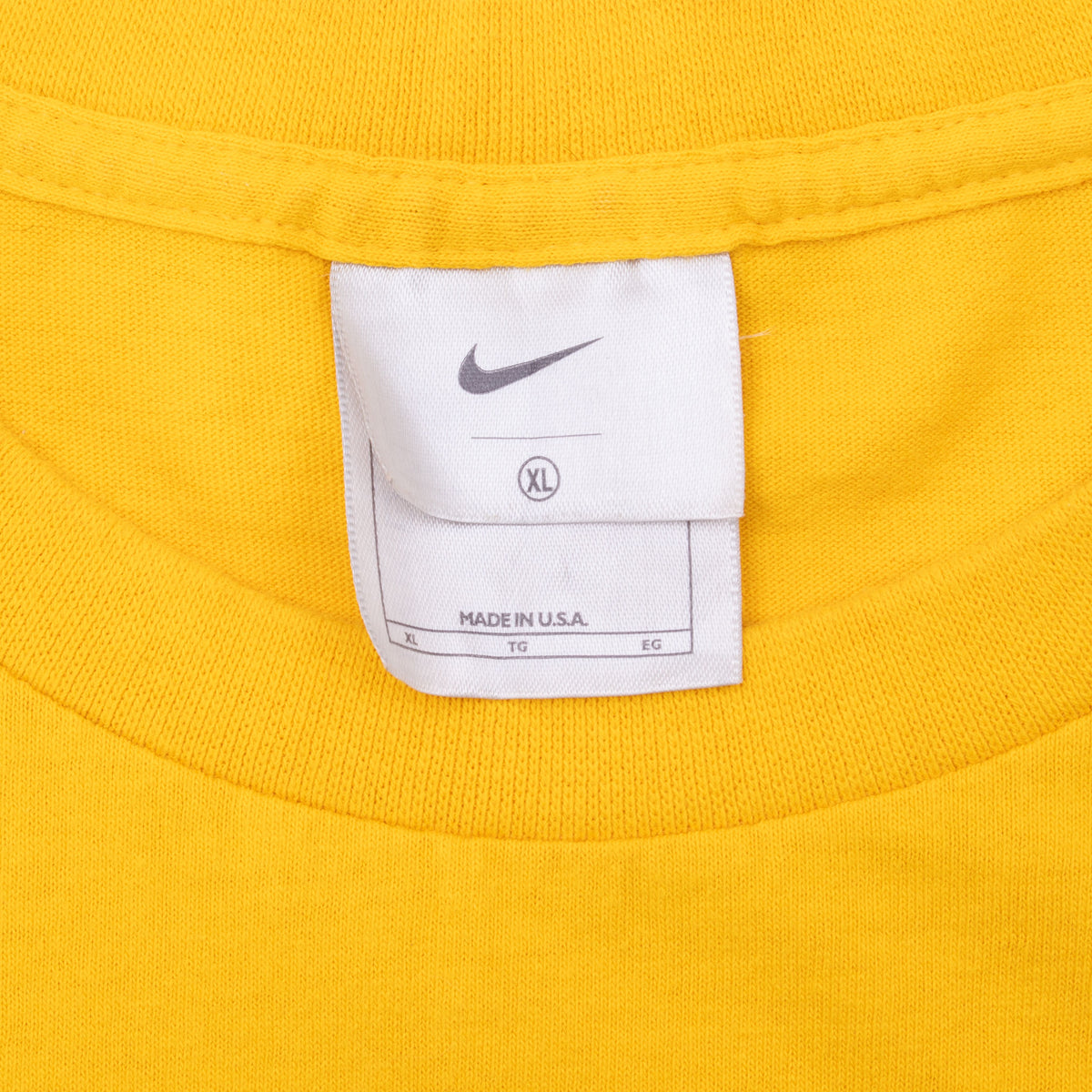 Nike neck tag showing XL and Made in U.S.A. inside yellow T-shirt