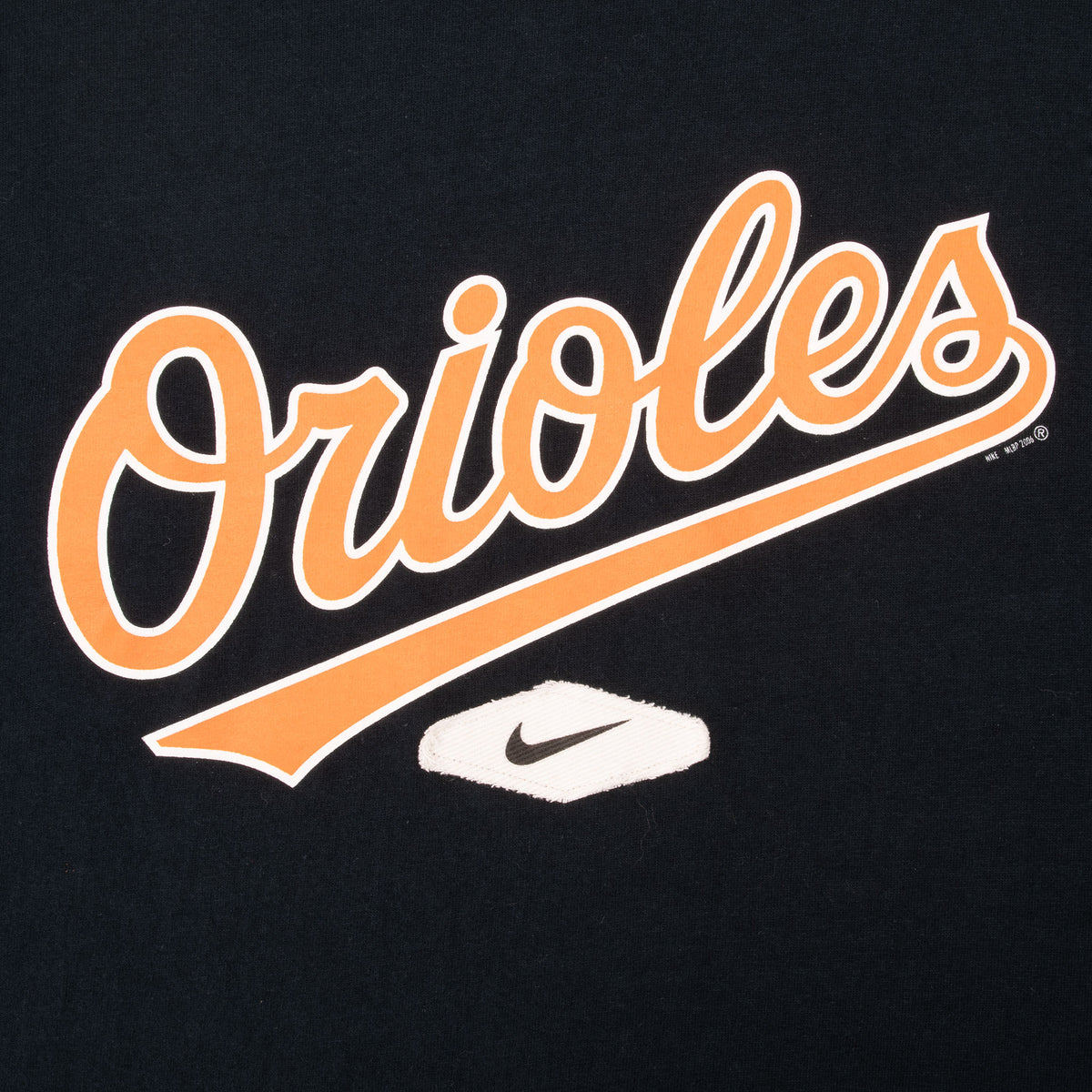 Orange Orioles script and Nike Swoosh chest print on navy fabric