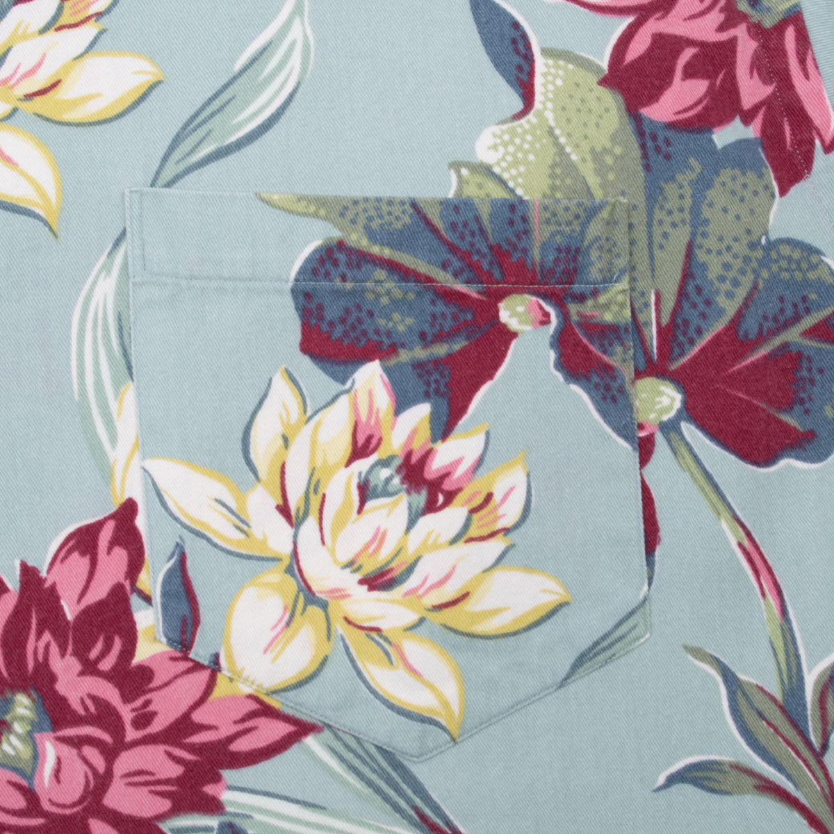 Chest pocket detail with aligned lotus floral print on light blue fabric