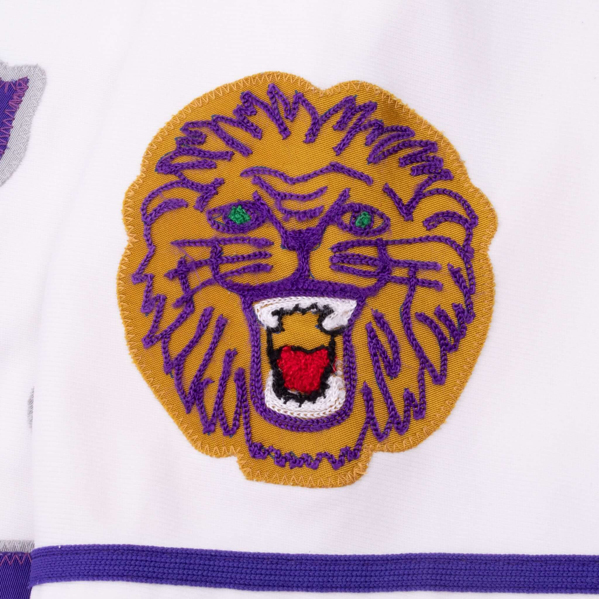 Close-up of embroidered purple and gold lion patch on jersey sleeve