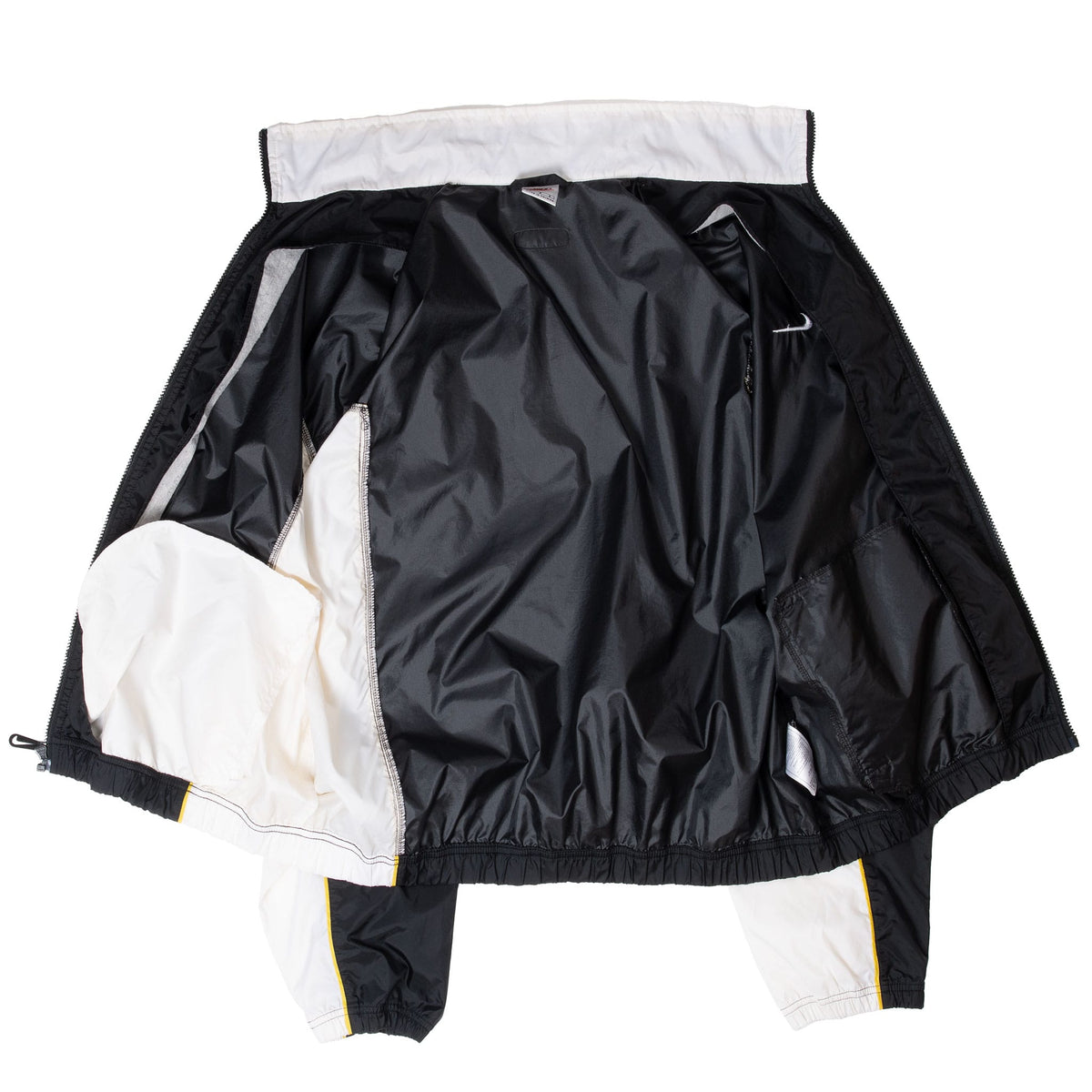 Interior view of unzipped black Nike windbreaker jacket with white color-block panels