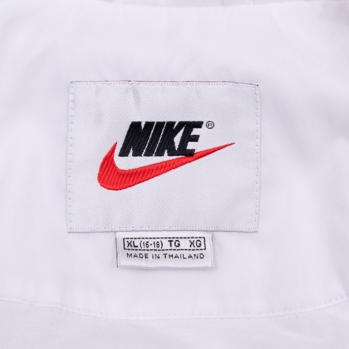 Nike neck label and women's XL size tag inside white windbreaker