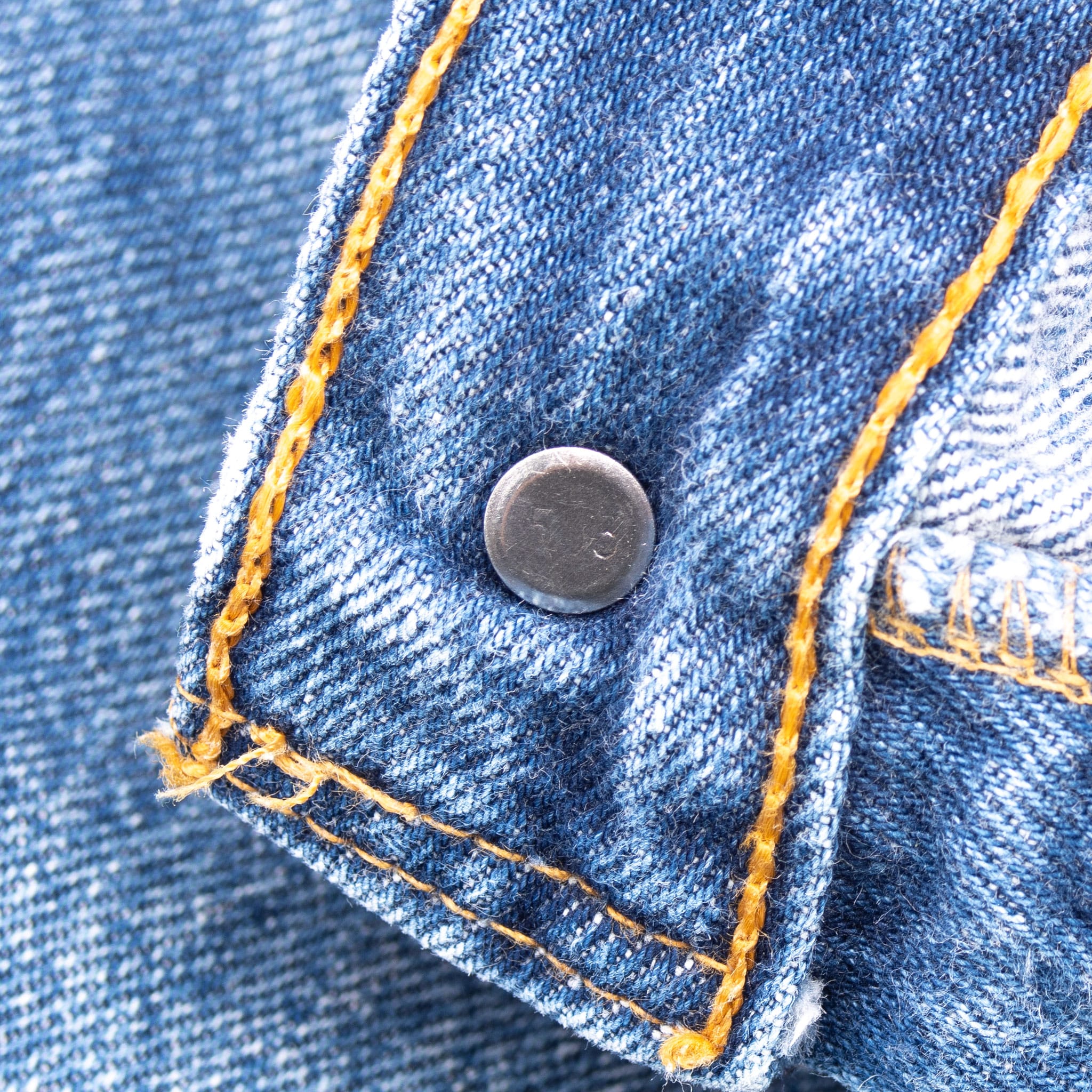 Close-up of metal rivet and contrast stitching on Levi's 501 jeans