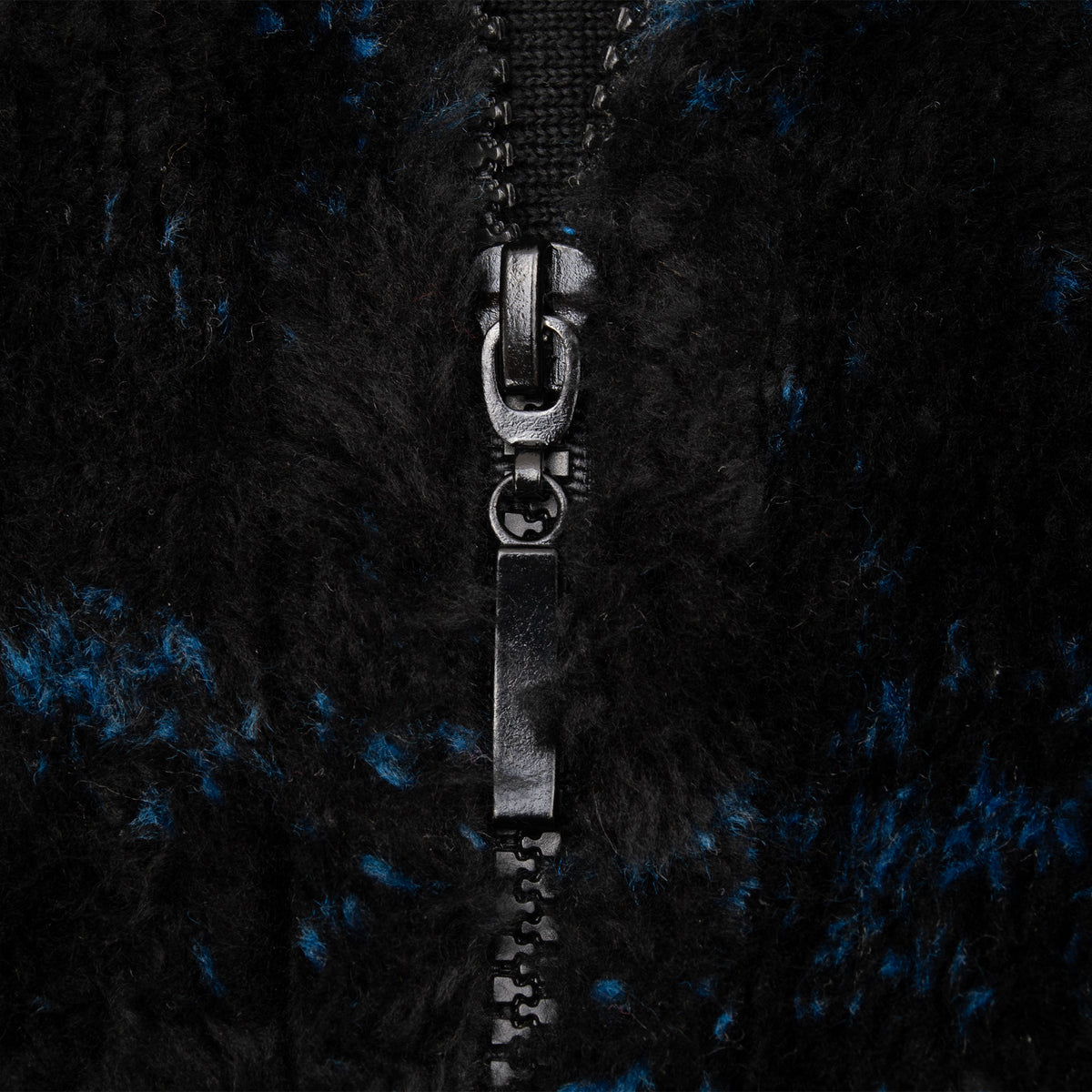 Close-up of black front zipper and plush fleece fabric