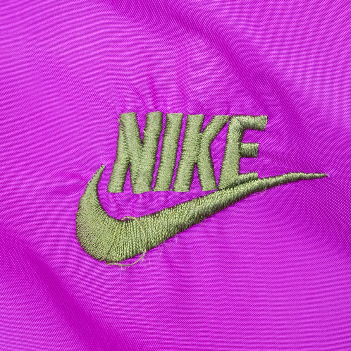 Green Nike Swoosh embroidery on purple chest panel