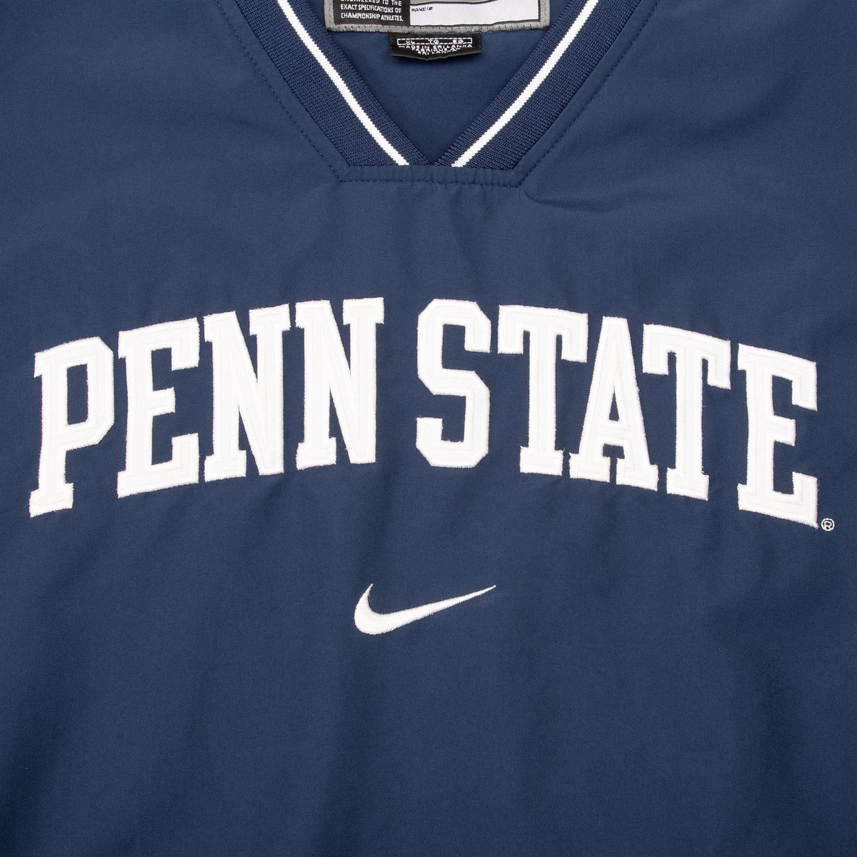 Close-up of white Penn State lettering and Nike Swoosh on navy chest
