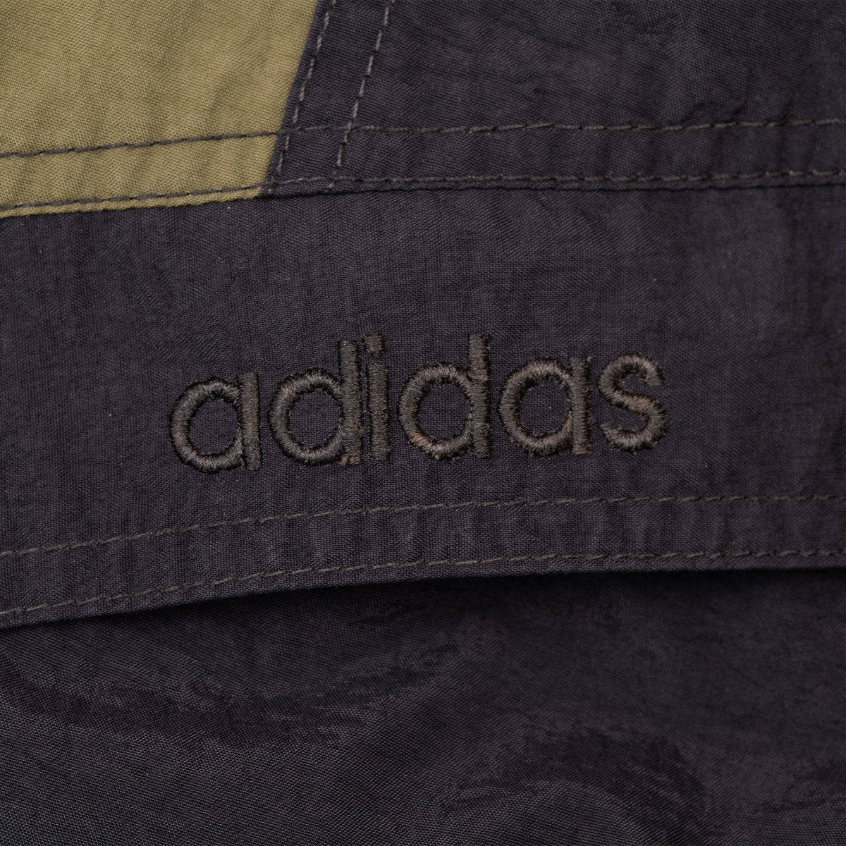 Close-up of tonal Adidas embroidery on the black chest panel