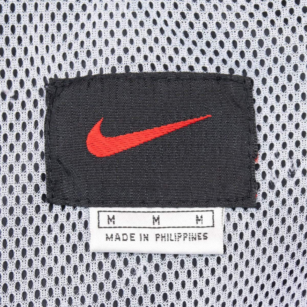 Nike neck label with red Swoosh, medium size and Made in Philippines text