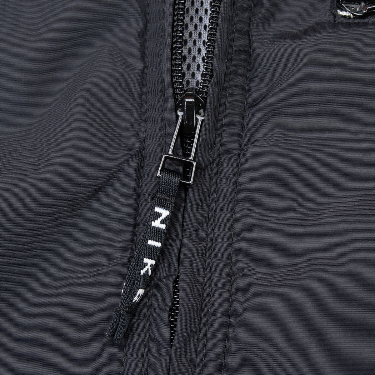 Close-up of black front zipper with Nike-branded fabric pull