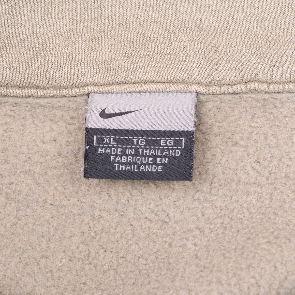 Nike neck label showing size XL on beige sweatshirt lining