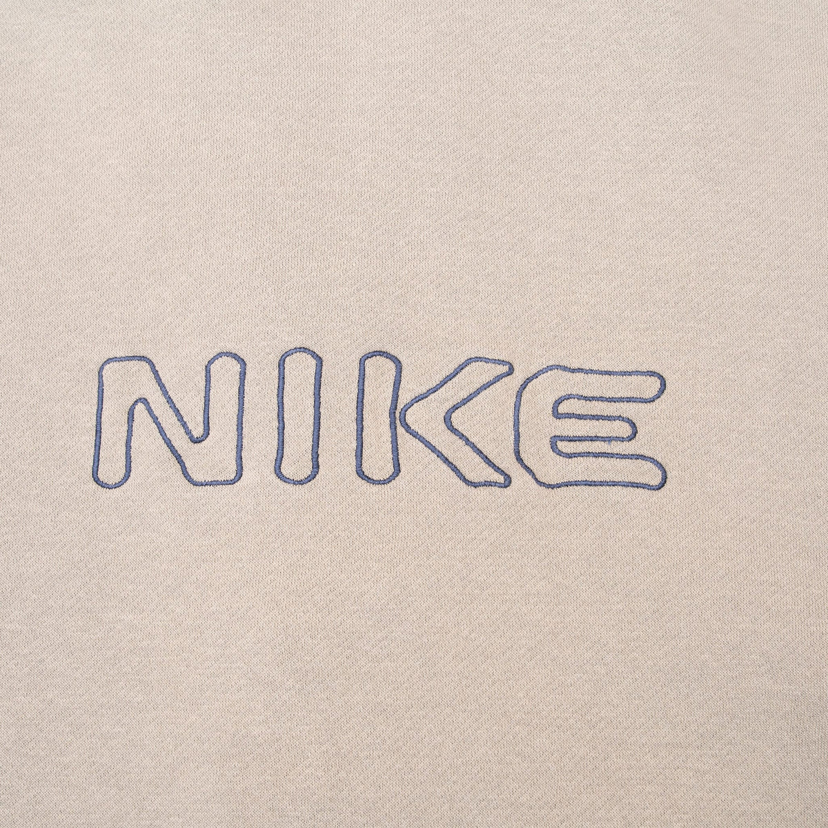Close-up of outlined navy Nike lettering embroidered across the upper back