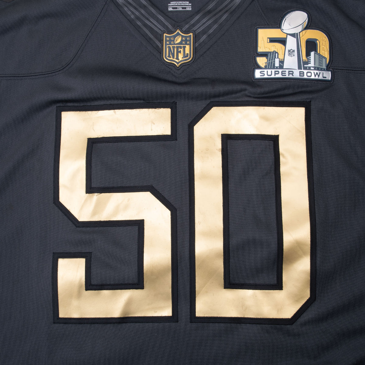 Close-up of gold number 50, NFL shield and Super Bowl 50 patch on jersey front