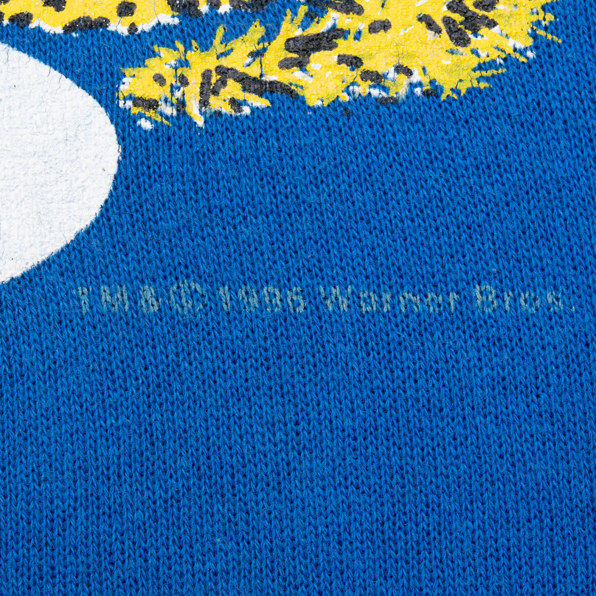Close-up of blue sweatshirt fabric and lower edge of the printed graphic