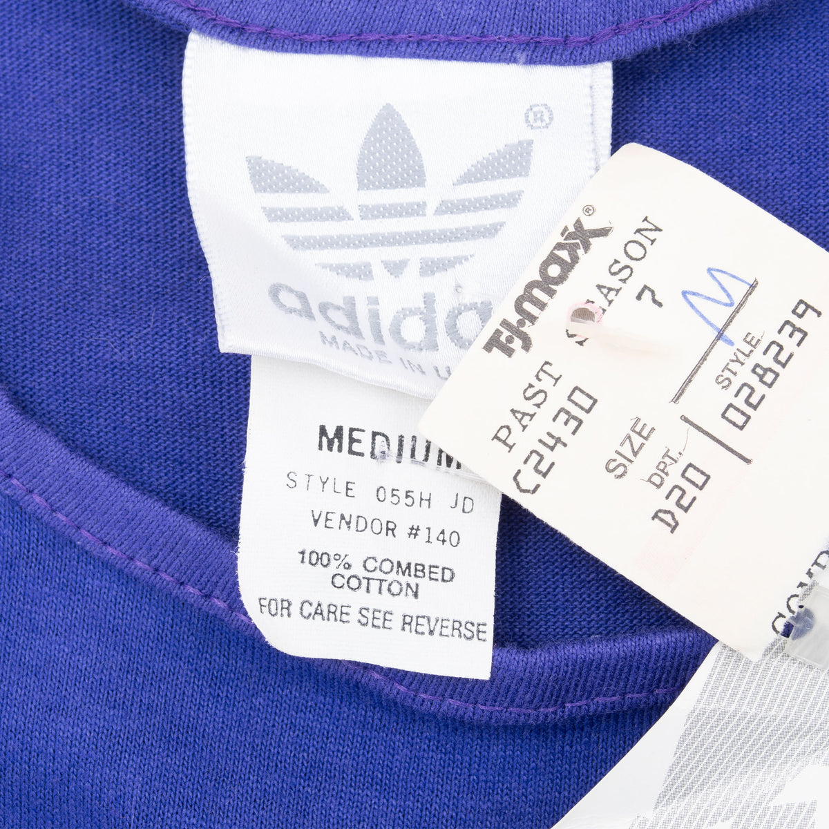 Adidas neck and care labels with medium sizing beside attached store tag