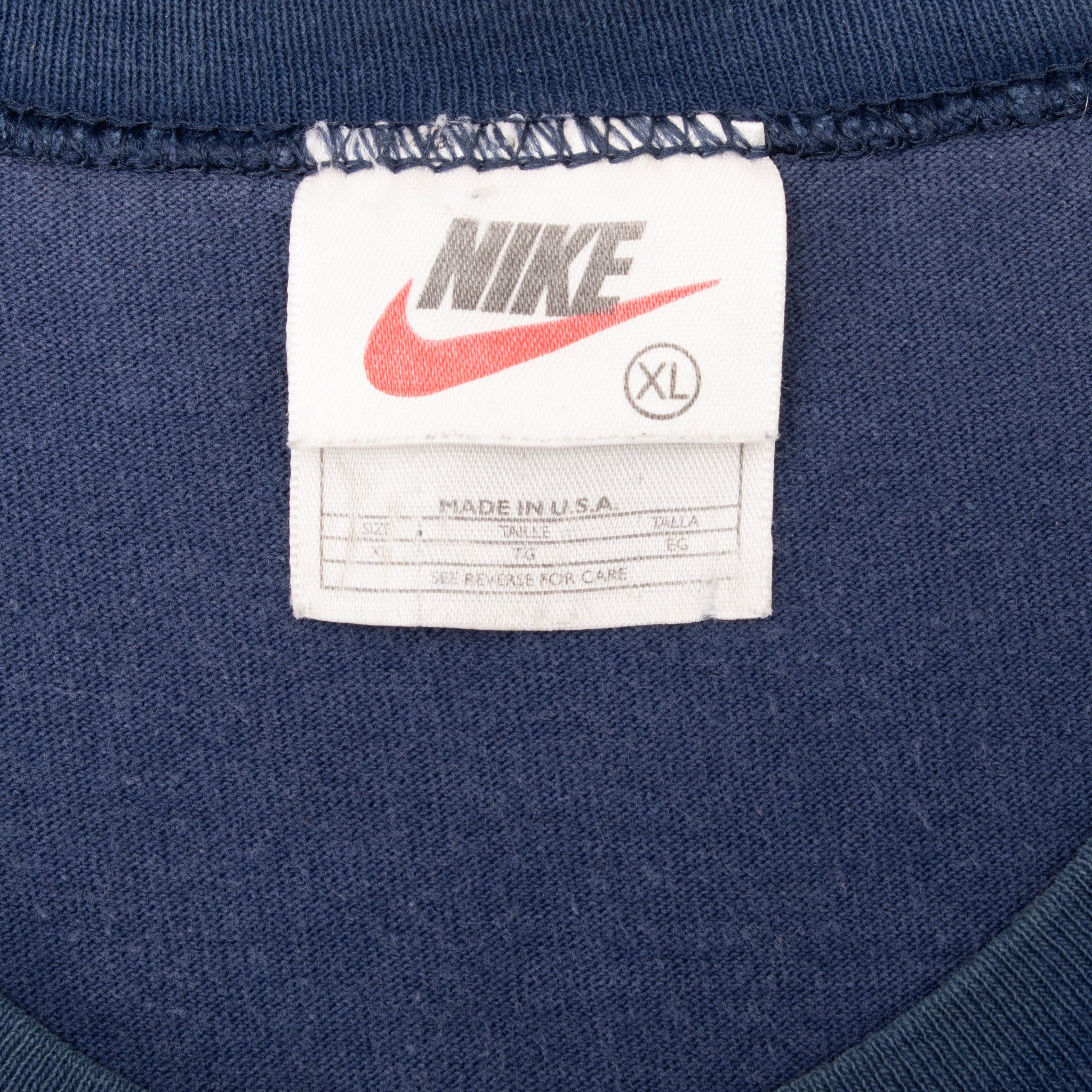 Nike neck tag marked XL and Made in USA inside navy sleeveless shirt