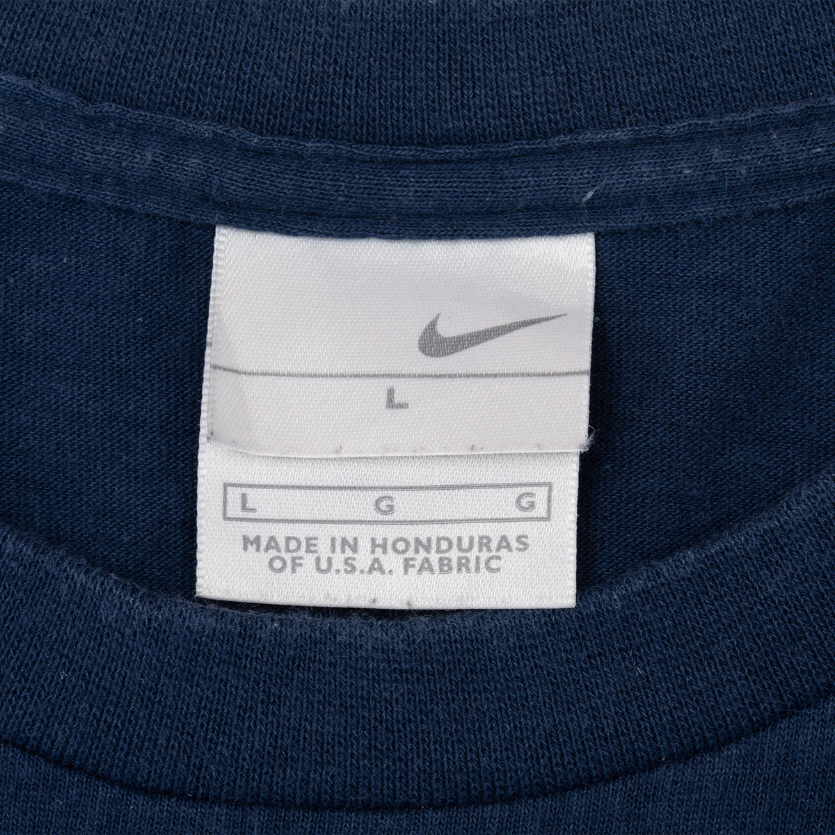 Nike neck tag showing size large on navy soccer T-shirt