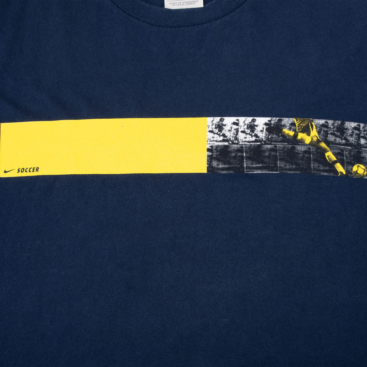 Close-up of yellow and black Nike Soccer chest print with player and ball