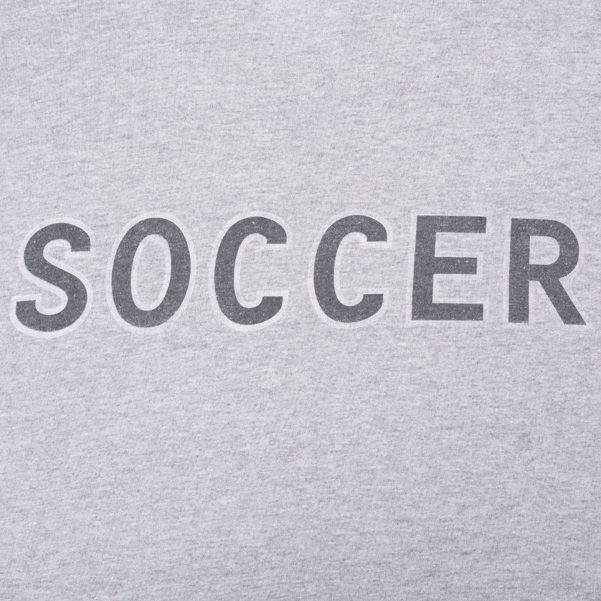 Close-up of dark SOCCER lettering printed across the grey tank top back