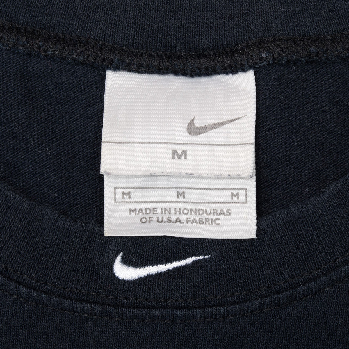 Nike medium neck tag and white Swoosh embroidery inside black tank top collar