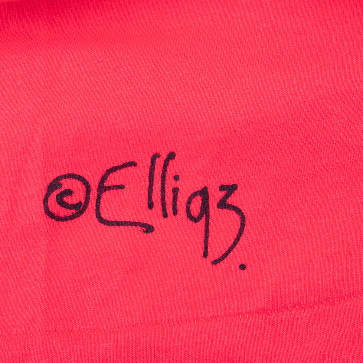 Close-up of Elli 93 painted signature near the T-shirt hem