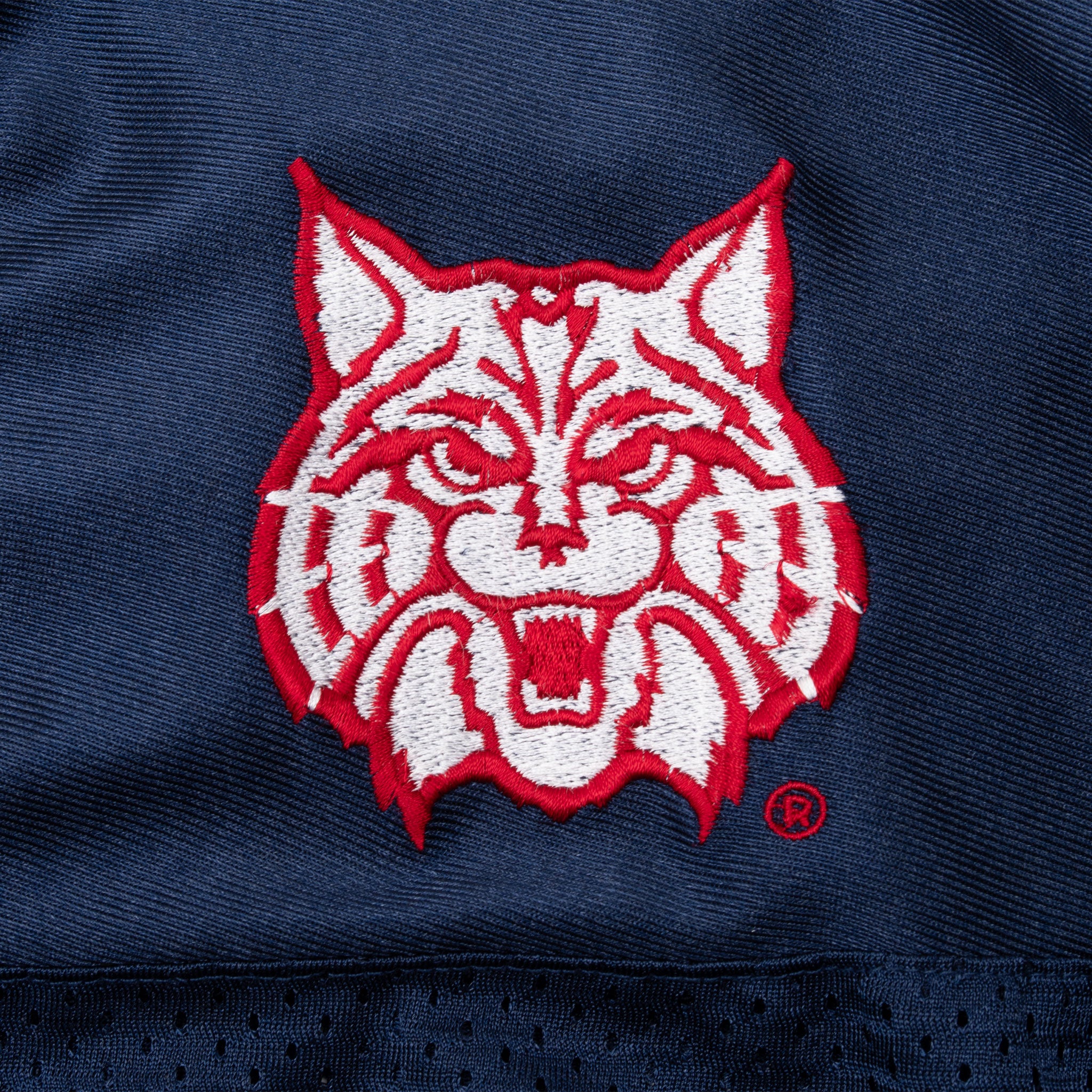 Red and white Arizona Wildcats mascot embroidery on navy jersey