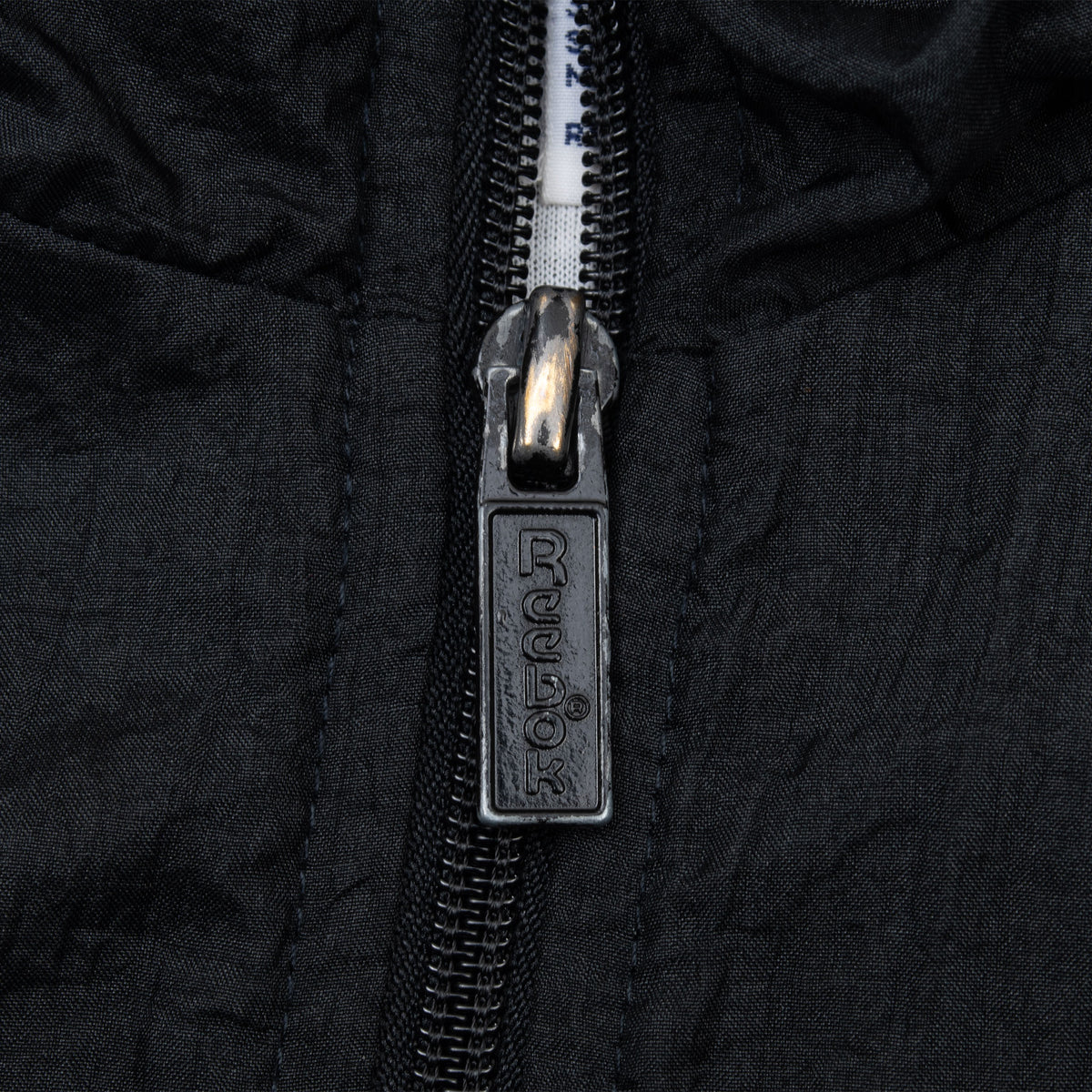 Close-up of black Reebok-branded zipper pull