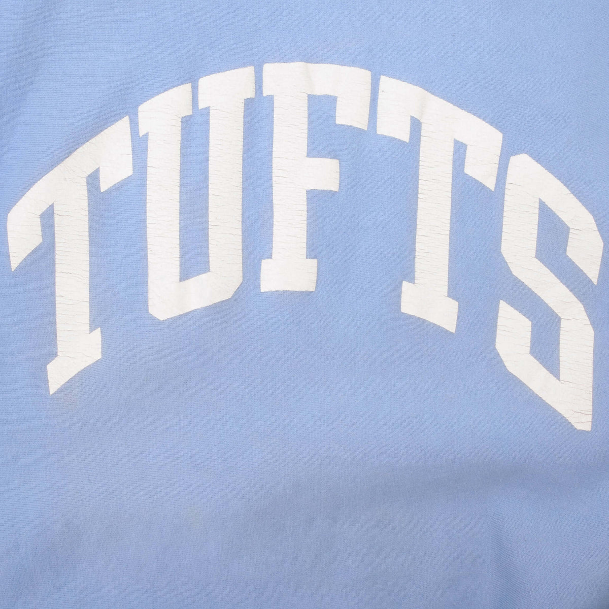 Close-up of white arched Tufts print on blue sweatshirt