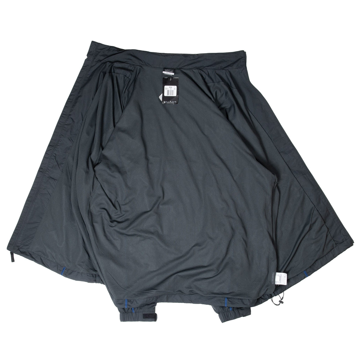 Interior of black Nike Golf windbreaker showing mesh lining, labels, and drawcord hem