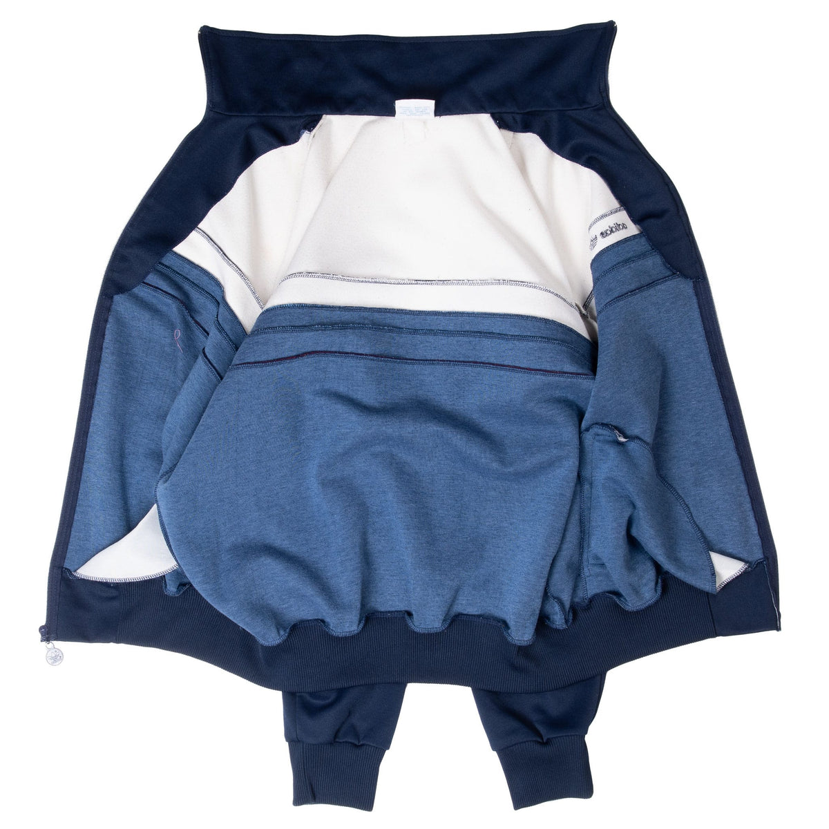 Inside view of open Adidas tracksuit jacket showing reverse seams, collar and ribbed hem