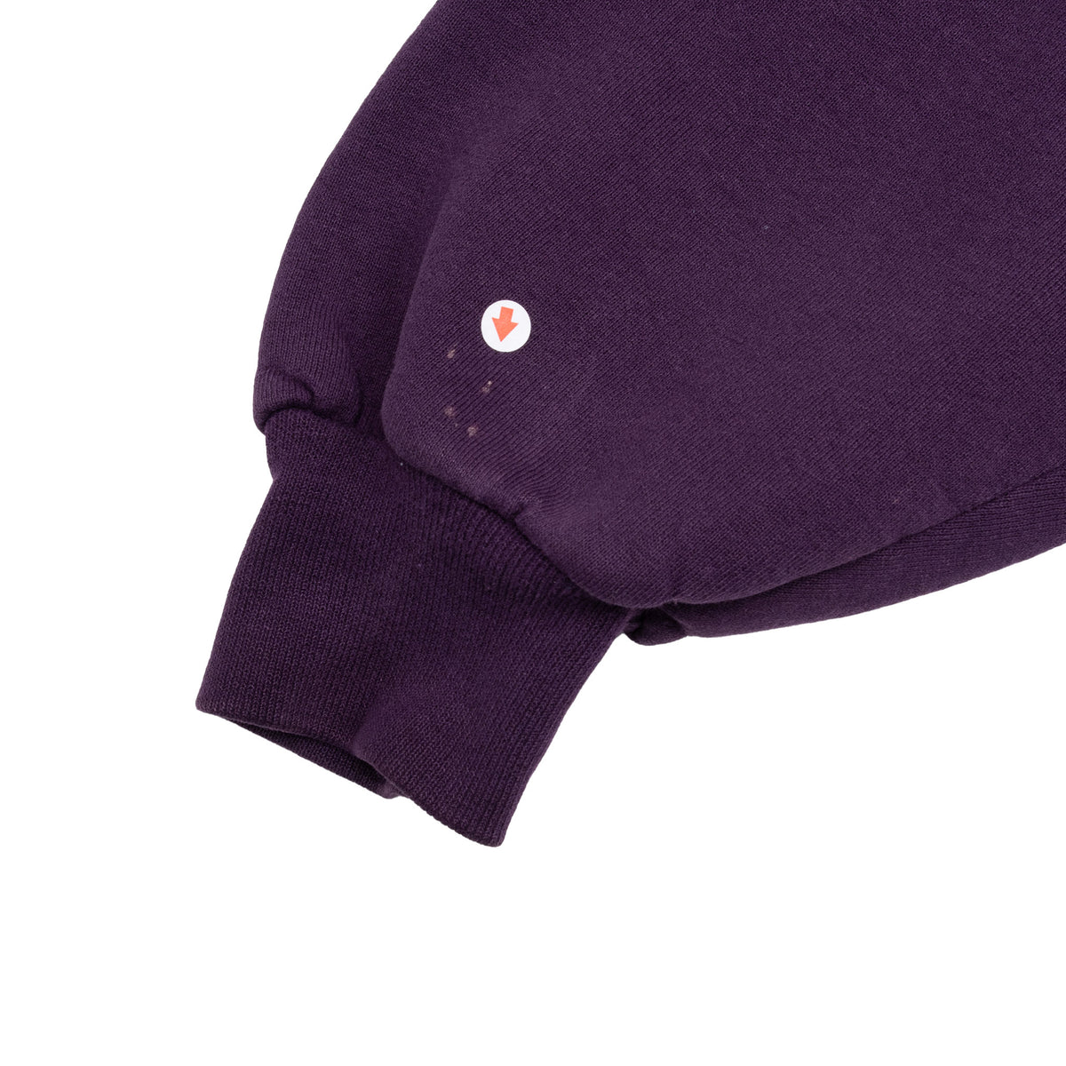 Purple sweatshirt sleeve and ribbed cuff detail with small marks indicated