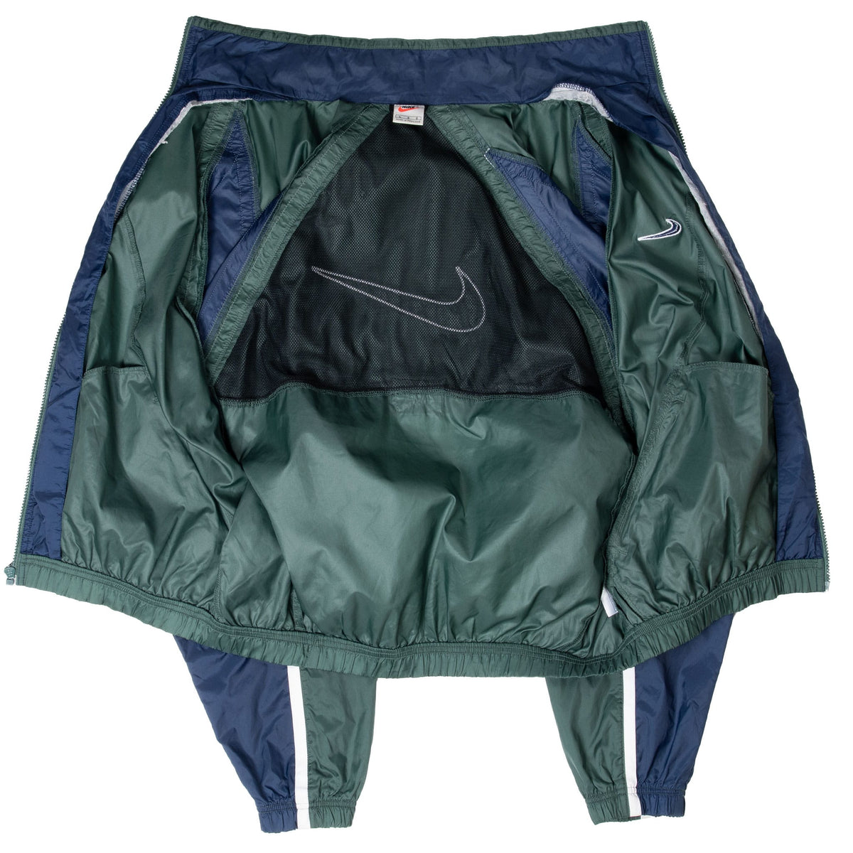 Interior view of green Nike windbreaker showing black mesh lining and inner Swoosh graphic