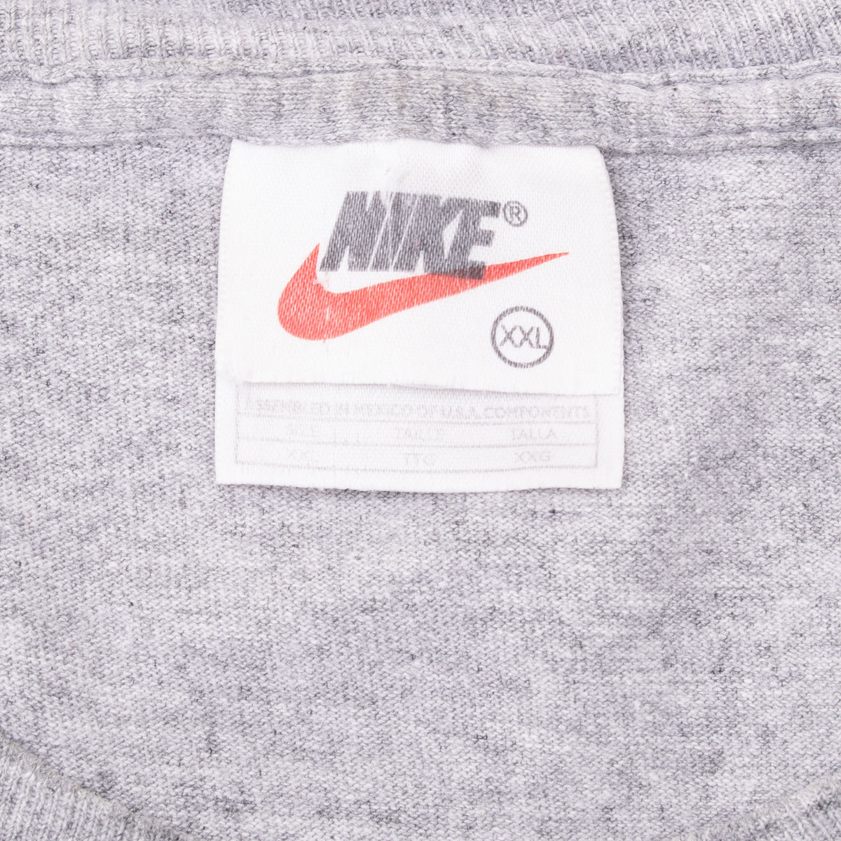 Nike neck tag with orange Swoosh and XXL size marking inside grey T-shirt