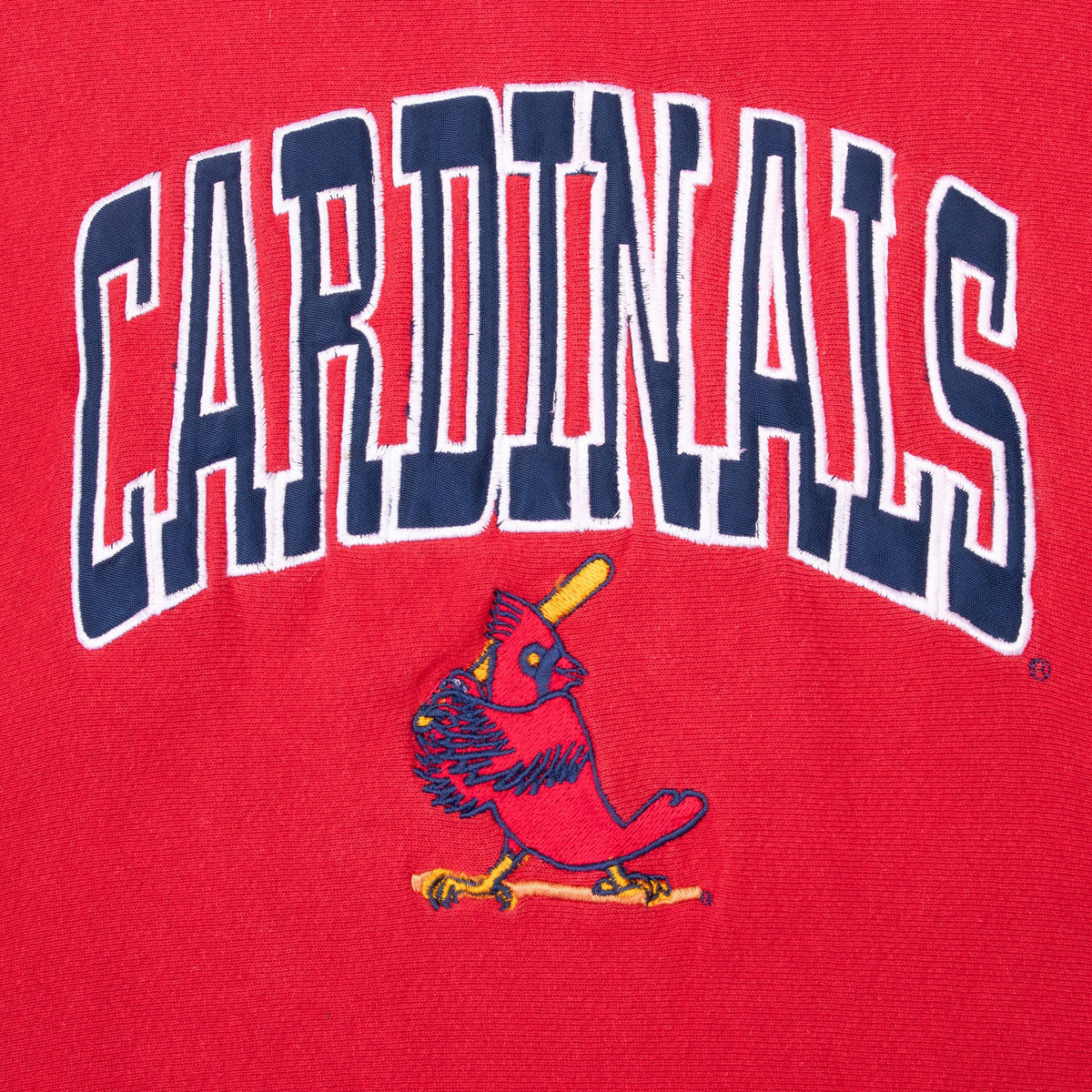 Close-up of arched Cardinals chest lettering and bird logo on red fabric