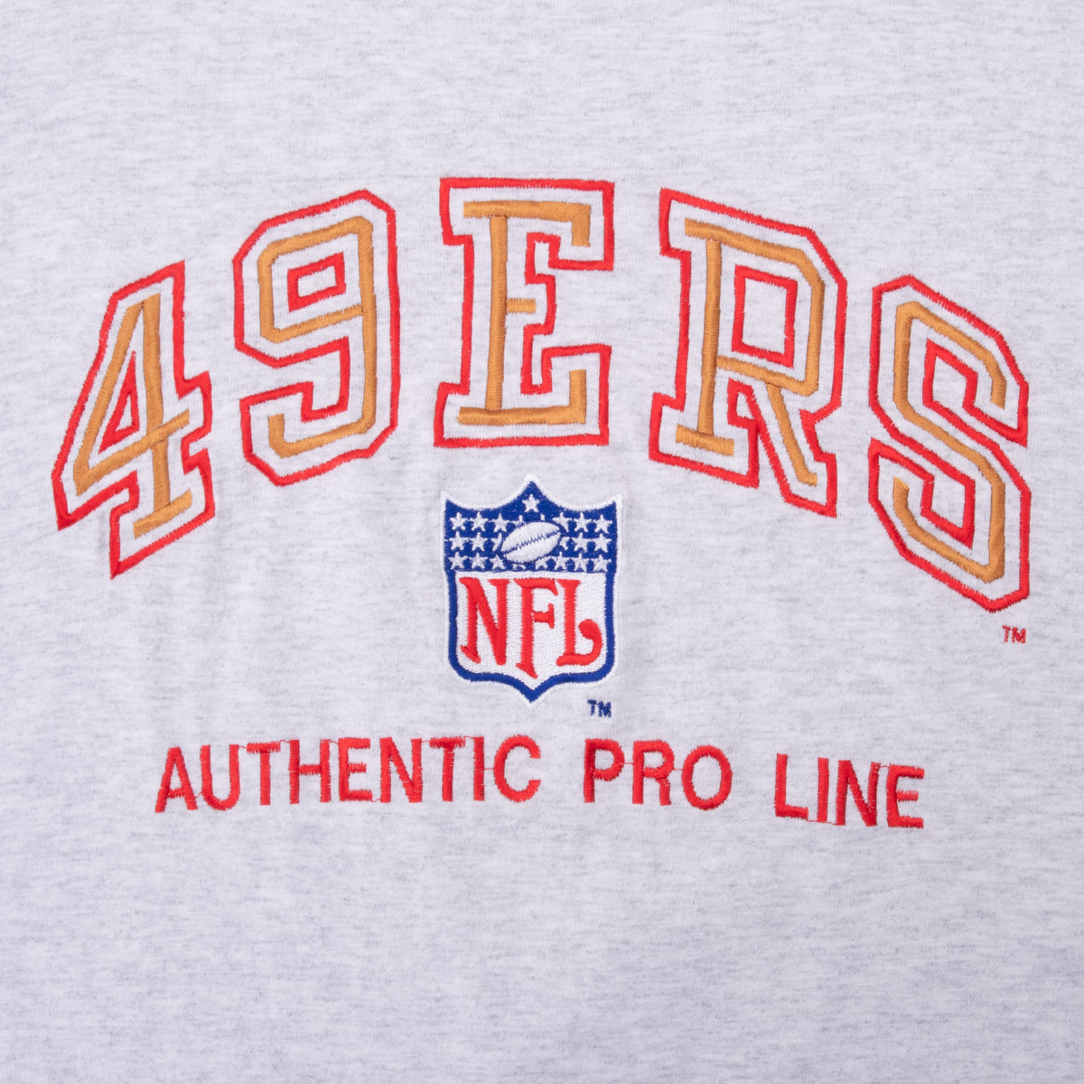 Close-up of red and gold 49ers lettering and NFL shield embroidery