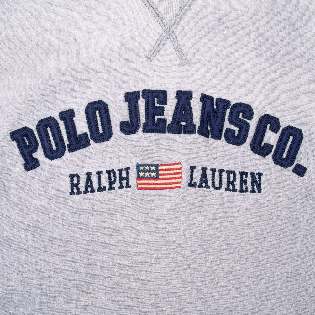 Close-up of navy Polo Jeans Co. appliqué, Ralph Lauren embroidery and flag motif