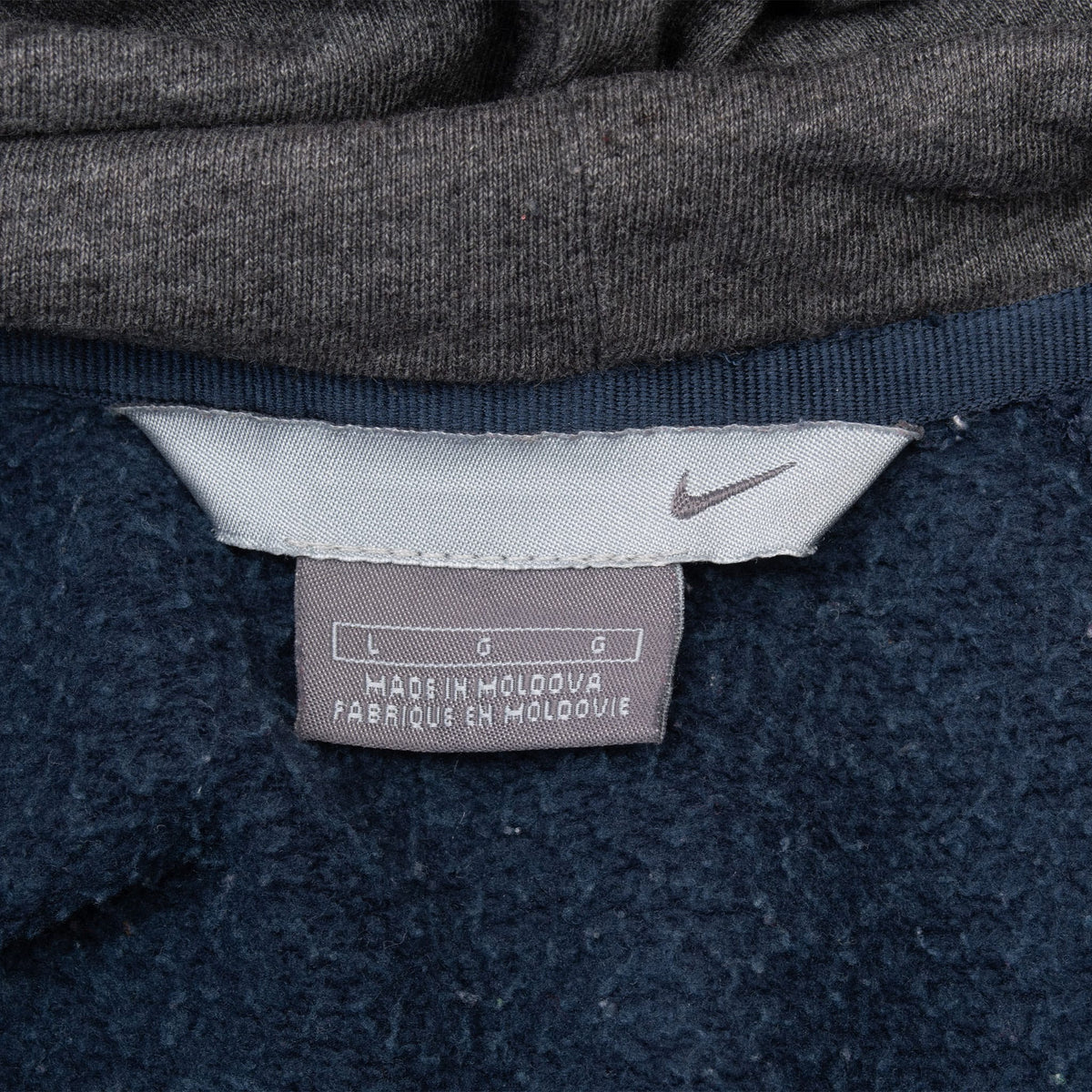 Close-up of Nike neck and size labels inside the navy blue hoodie