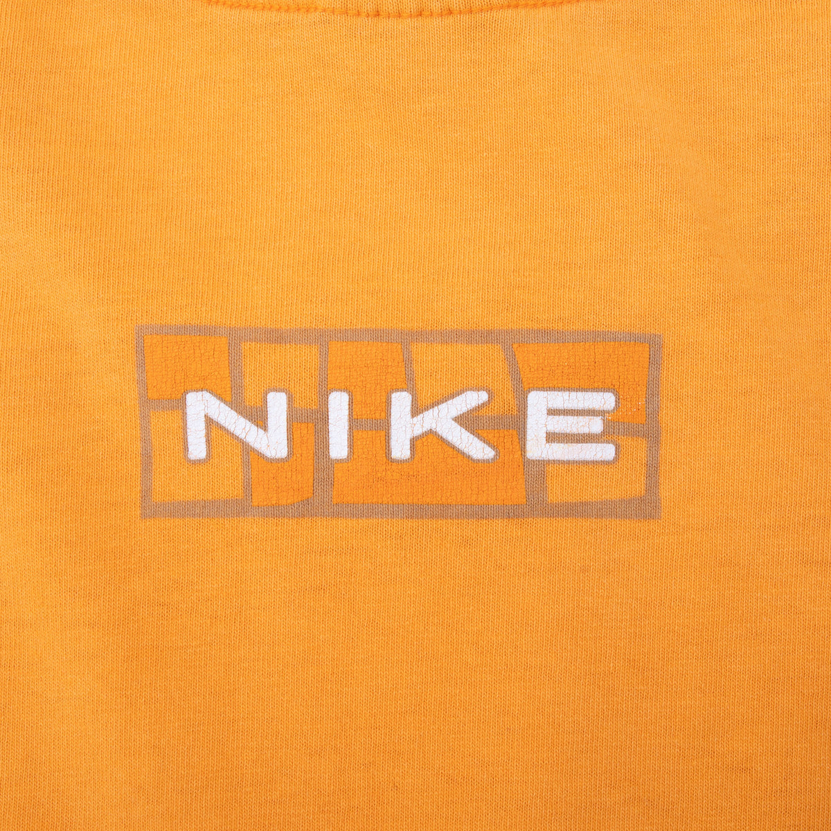 Close-up of white Nike wordmark and outlined grid graphic below back neckline