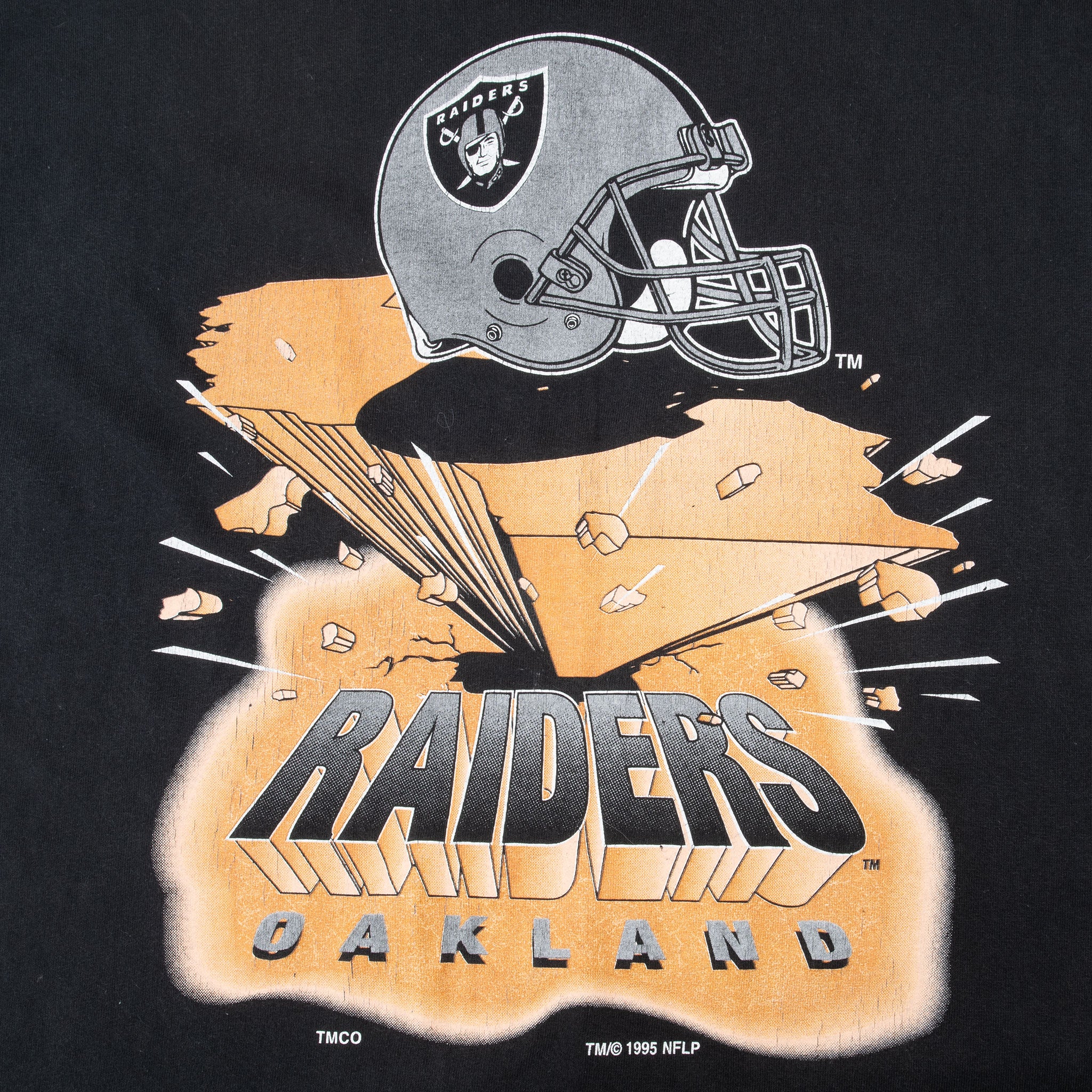 Close-up of Oakland Raiders helmet and orange front graphic on black T-shirt