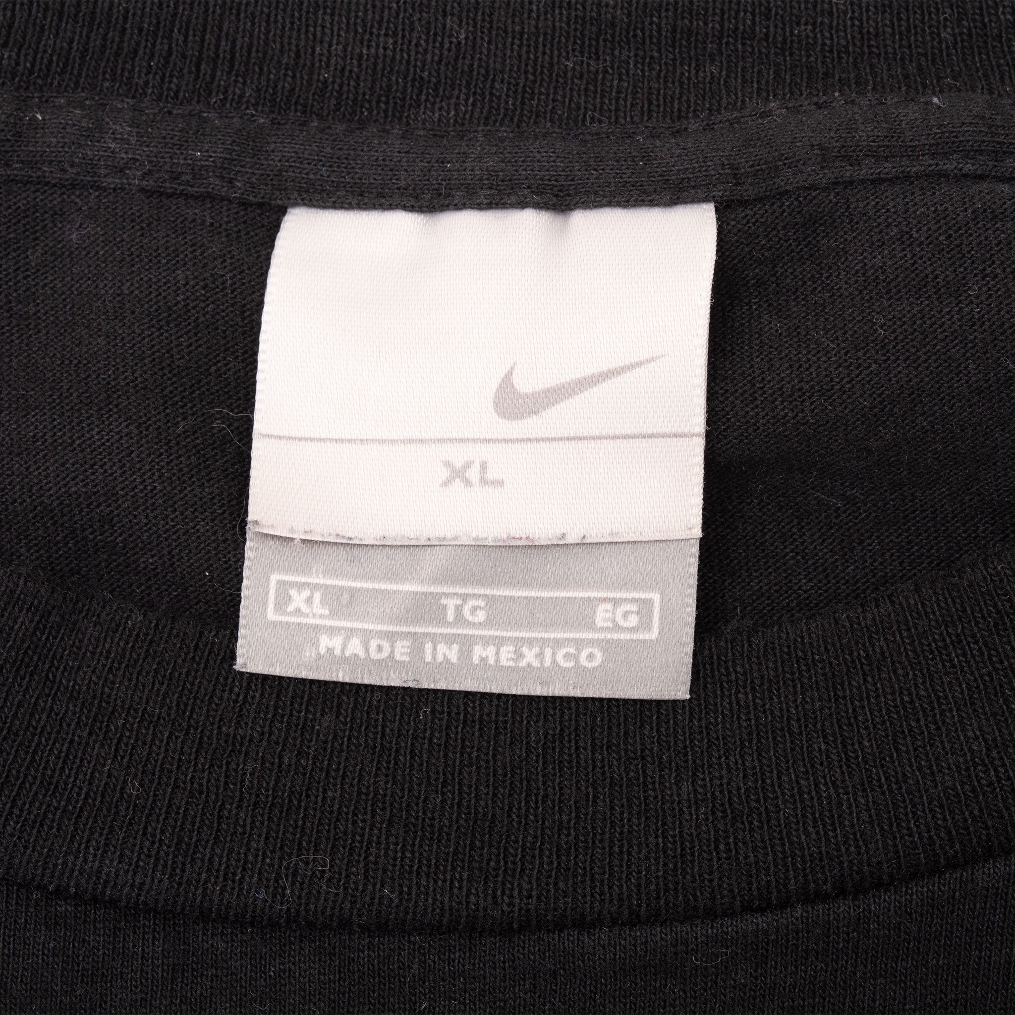 Close-up of Nike neck tag marked XL inside black T-shirt