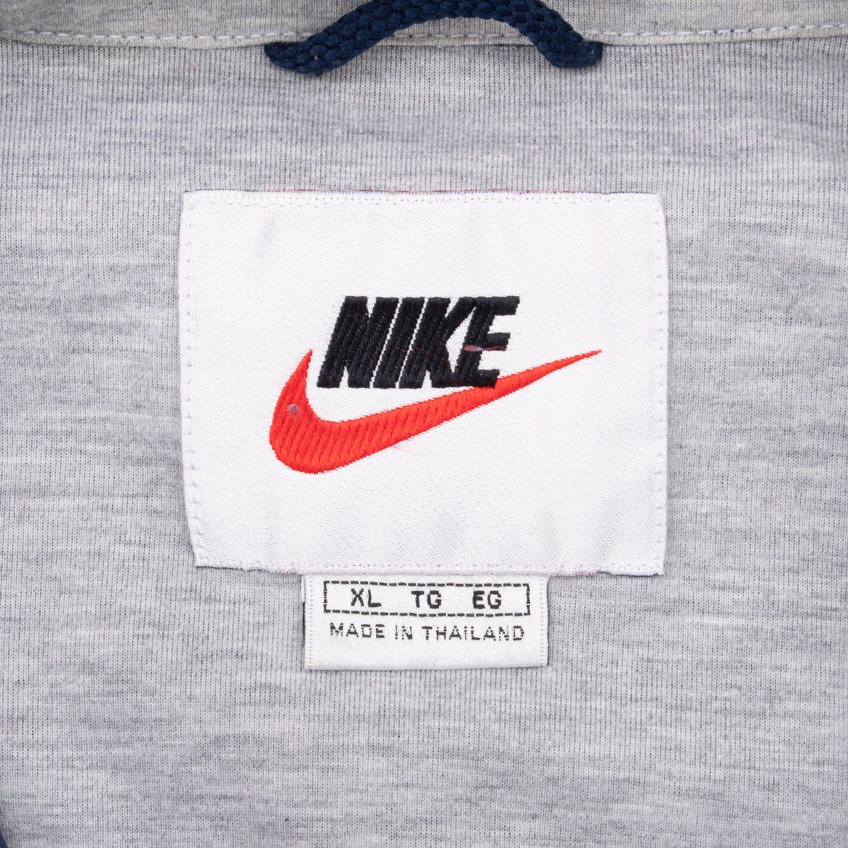 Nike neck label and size XL tag inside gray windbreaker collar