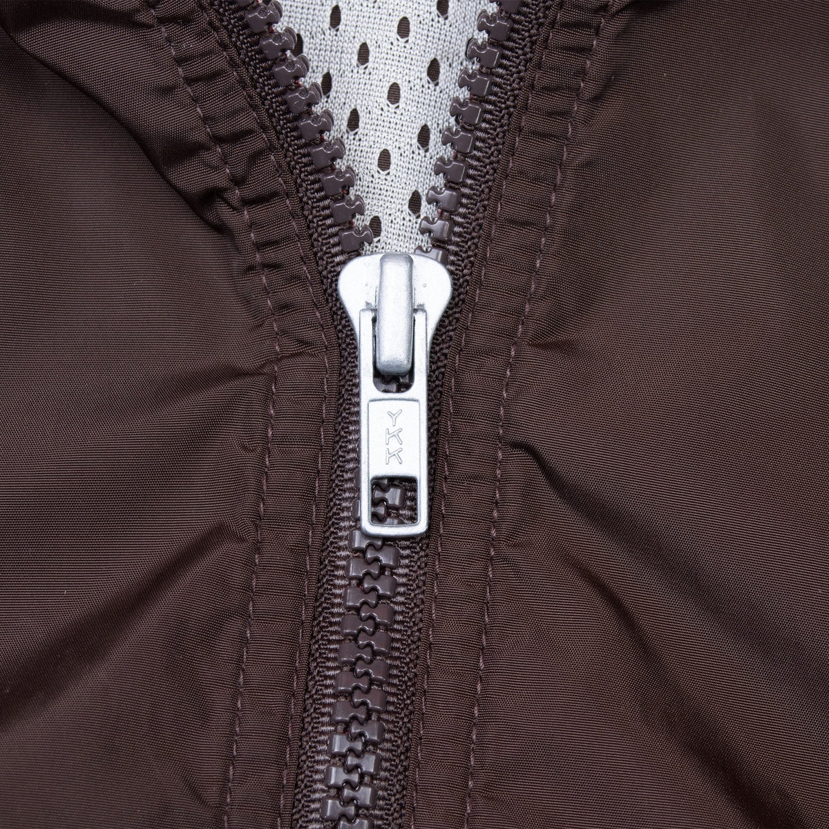 Close-up of front zipper and mesh lining on brown Nike windbreaker