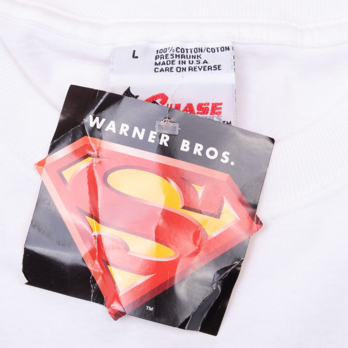 Close-up of size L neck label and attached Warner Bros. Superman hangtag