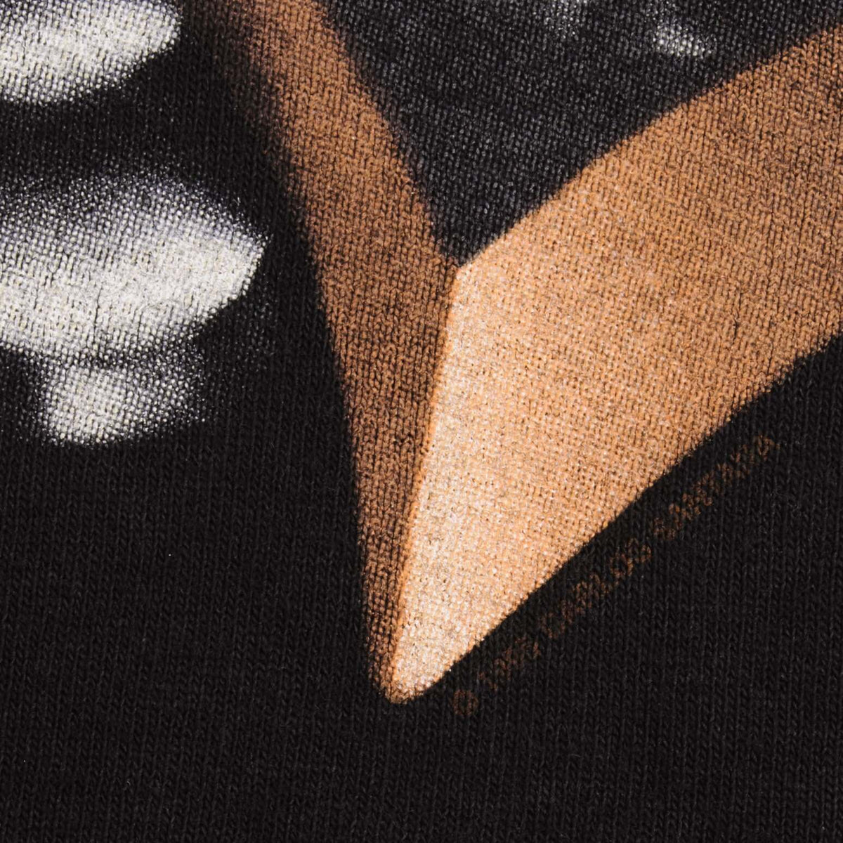 Close-up of orange, white and black screen print texture on the shirt