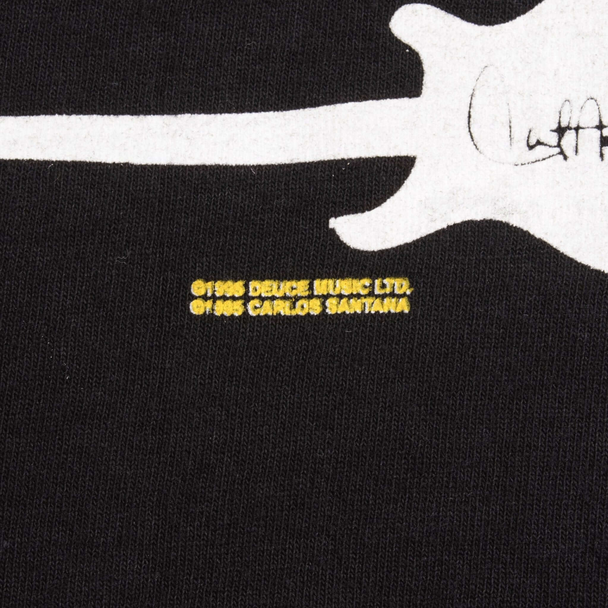 Close-up of 1996 copyright print beneath a white guitar on the back graphic