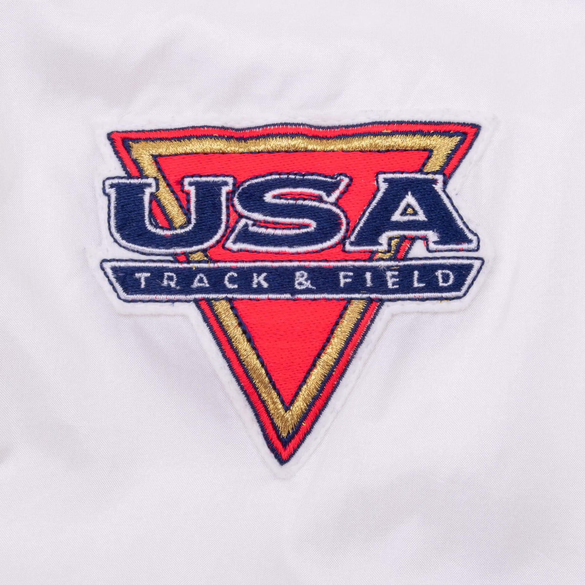 Close-up of embroidered USA Track & Field chest patch in red, navy, and gold