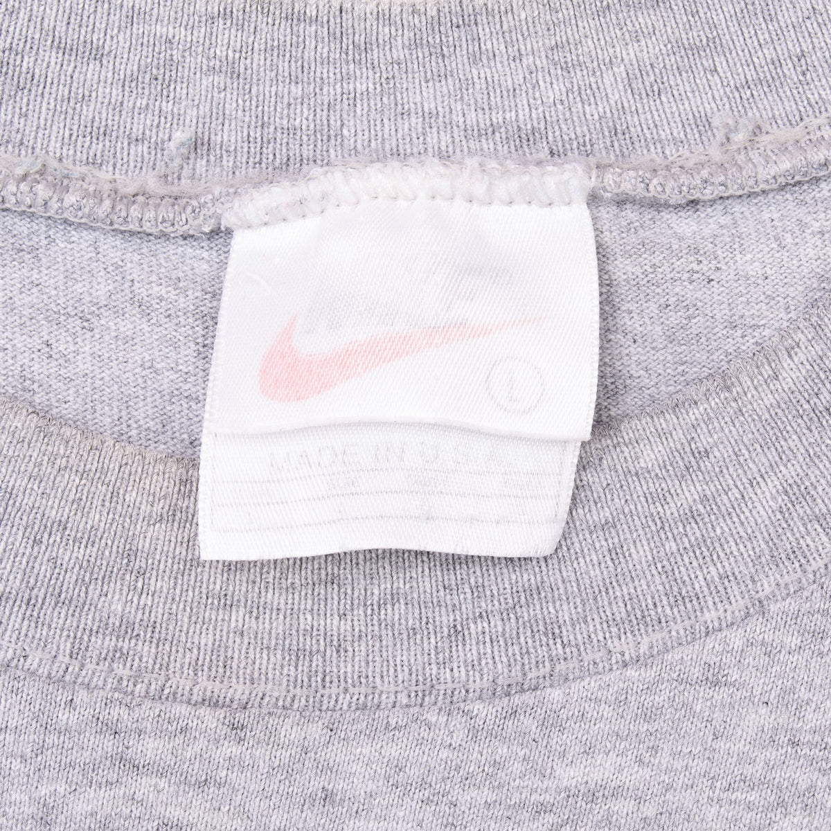 Close-up of faded Nike neck tag inside grey tank top